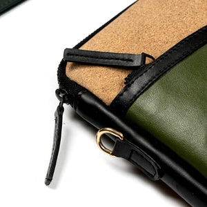 Close-up of a green phone case with cork back and black zipper on a white background