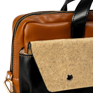 Close-up of a brown, black, and beige handbag with a visible brand logo.
