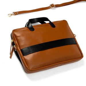 Brown vegan leather briefcase with black strap and handle on a white background