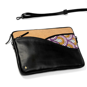 Black vegan leather clutch with cork interior and colorful patterned pocket on a white background