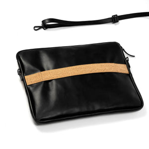 Black vegan leather clutch with a cork strip on a white background