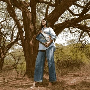 Woman holding a blue bag in a forest setting