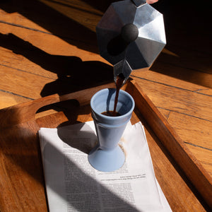 blue mazagran coffee cup on a wooden breakfast tray - coffee being poured