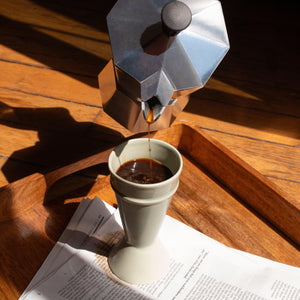 green mazagran on a breakfast tray - coffee being poured