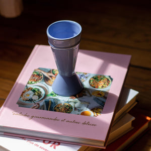 blue mazagran coffee cup on a pink stack of books