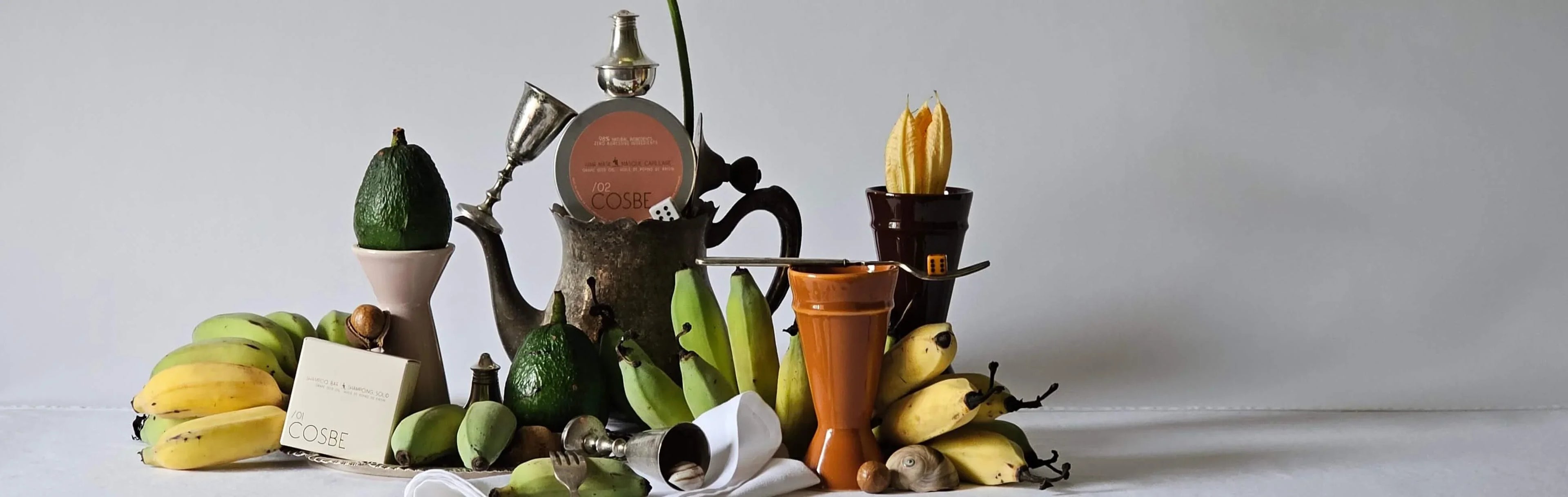 Still life arrangement with fruits, vegetables, and decorative items on a white background