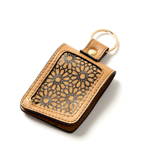 Brown leather key fob with geometric pattern on a white background
