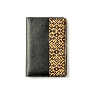Black vegan leather passport wallet with gold geometric pattern on a white background
