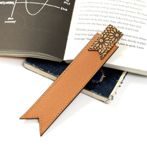 Brown vegan leather bookmark with decorative end on an open book