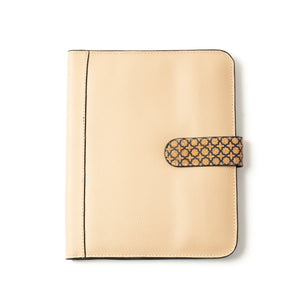 Beige leather diary case with a decorative strap on a white background