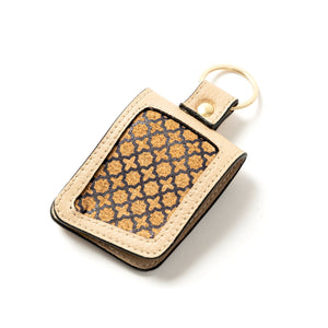 Keychain with beige vegan leather and patterned interior on a white background
