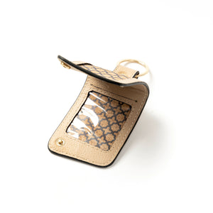 Gold keychain card holder with patterned interior on a white background