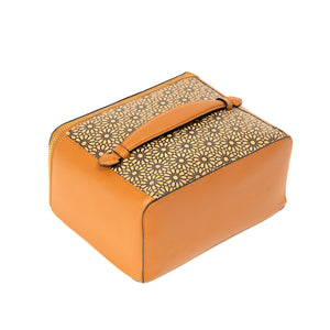 Tan cosmetic bag with decorative patterned flap on a white background