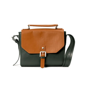 Black and brown handbag made from vegan friendly banana leather with a buckle on a white background