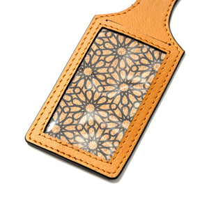 Brown vegan leather luggage tag with geometric pattern on a white background