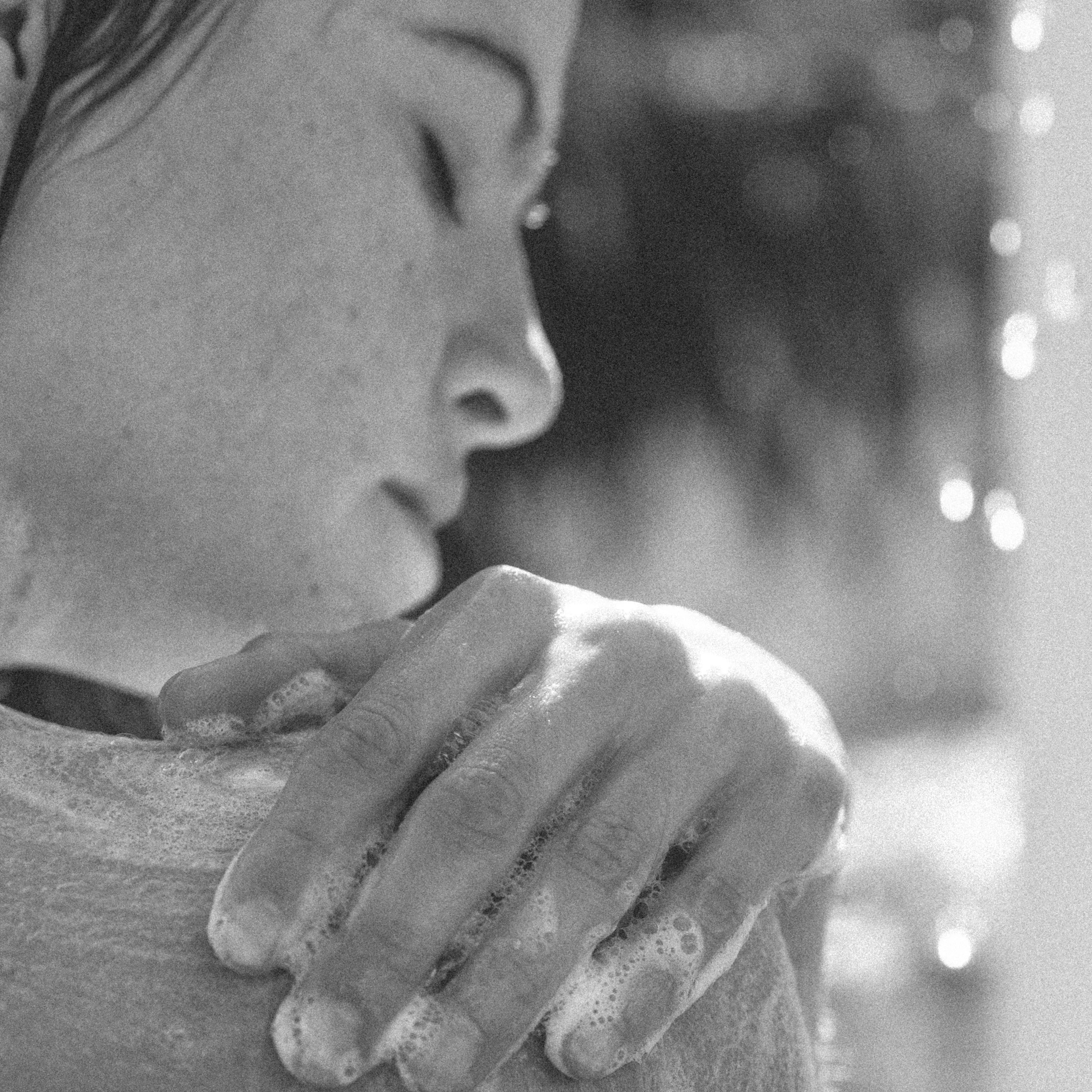 Black and white statue of a woman with a hand on her shoulder against a blurred background using Mircea body & hand wash