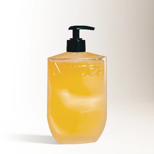 Yellow bottle with black pump on a light beige background