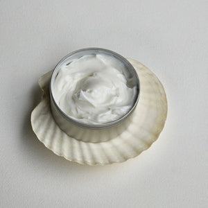 tin of white cream Cosbe hair conditioner made from waste after the Portuguese wine harvest on a shell with a light gray background