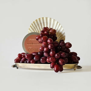 Bunch of red grapes on a decorative plate with aCosbe product in the background