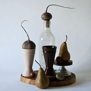 Artful collection of curios sitting on a wooden board with two Mazagran Coffee Cups