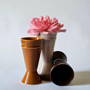 Caramel, Chocolate and blush pink Mazagran coffee cups arranged with a pink rose on a white background