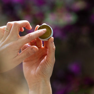 grums coffee oil lip balm. blurred purple flower background