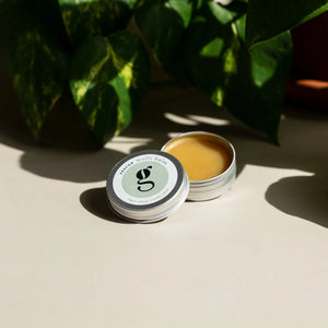 Two small containers of a yellowish-brown substance with a green leafy background