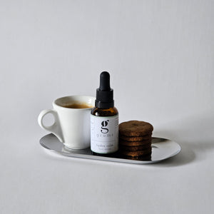 grums vegan hydra calm serum made with coffee oil shown on a tray with a cup of coffee