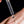 Dropper with a drop of liquid held above skin on a black background