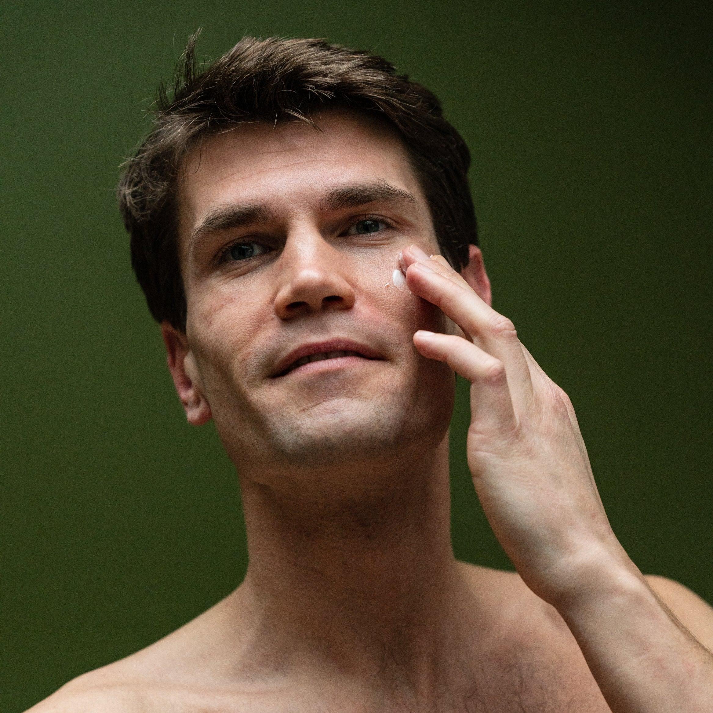 man applying hydra calm moisturizer to his face