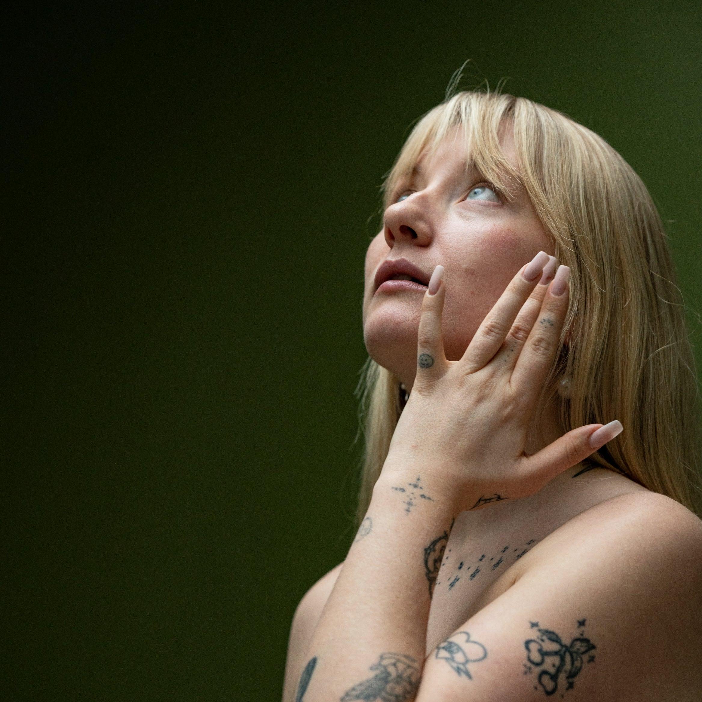 female applying hydra calm moisturizer to her face