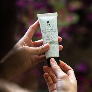 a tube of grums espresso face mask shown against a floral background
